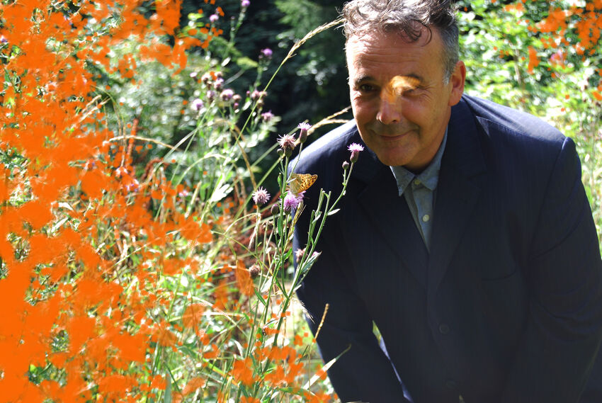 Rob Newman in a field with orange flowers