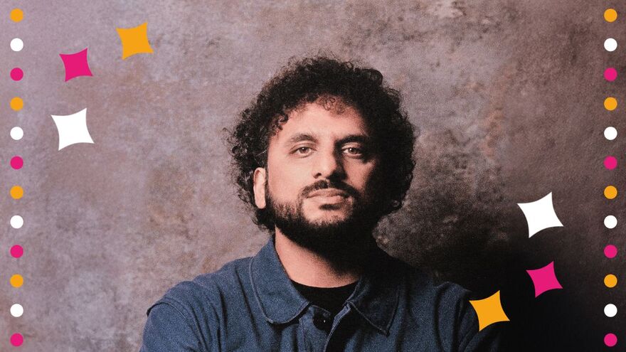 Nish Kumar wearing a navy shirt staring at the camera. There are white, pink and yellow cartoon stars and dots around him
