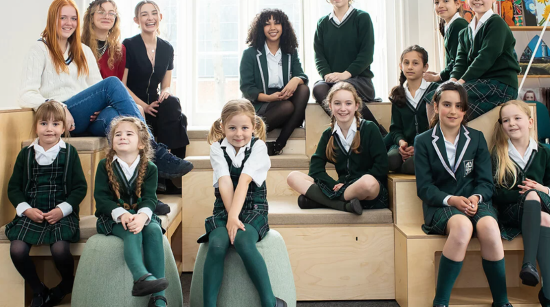 Group of girls in school uniform sitting on steps