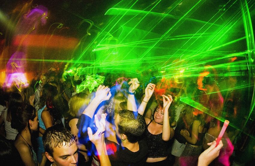 Youjng people raving surrounded by neon green light