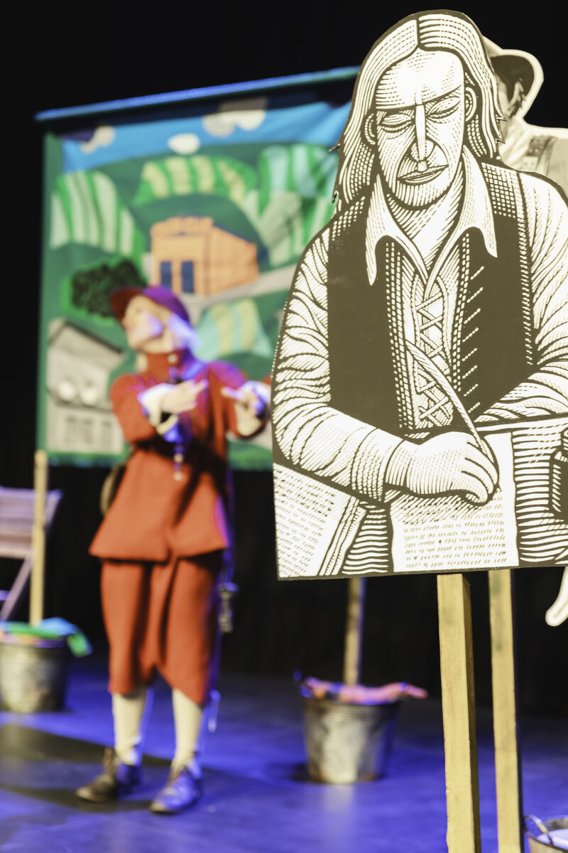 Victoria Melody wearing a medeival royalist costume is blurred behind a cut out of Gerrard Winstanley, founder of the diggers.