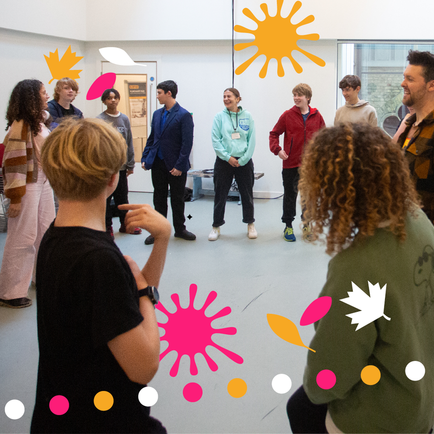People standing around in a circle in a bright room, with pink, yellow and white spots around them