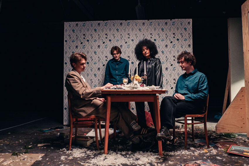 The four members of English Teacher gathered round a square table