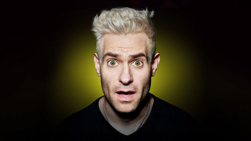 A white man with bleech blonde short white hair