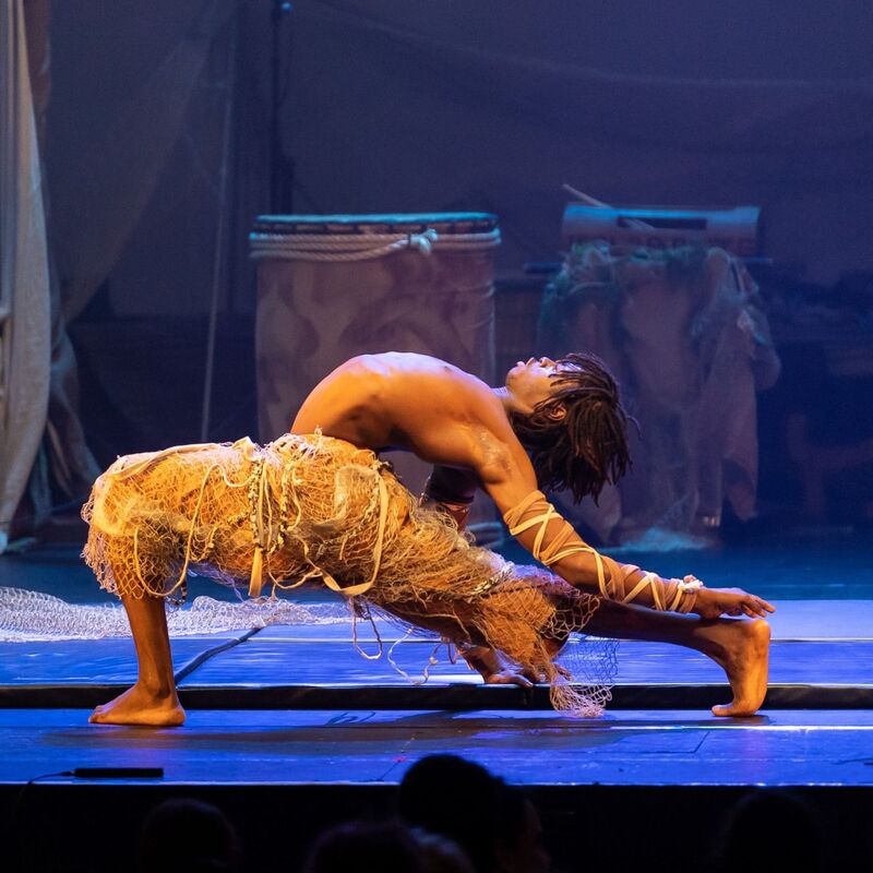 A contortionist in a deep lunge and back bend