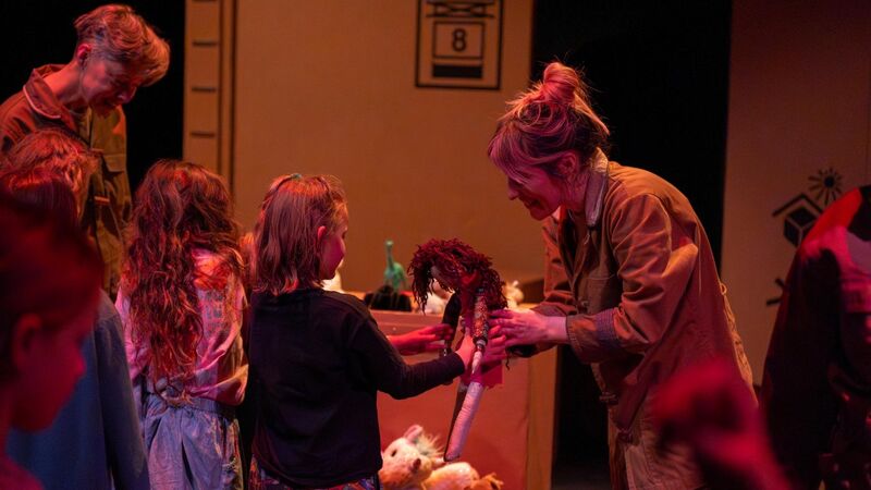 A woman hands back a toy to a little girl