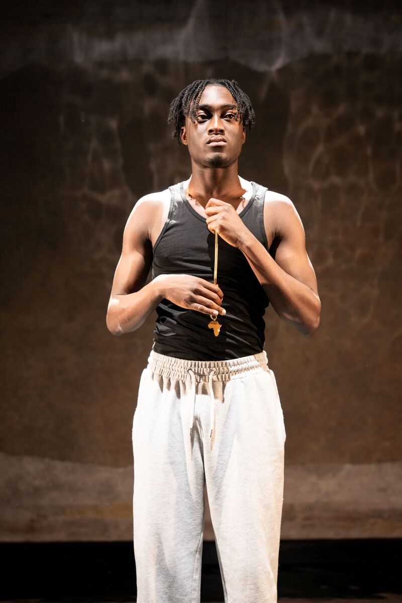 Selorm Adonu stand on stage holding a necklace that is the outlie of Africa