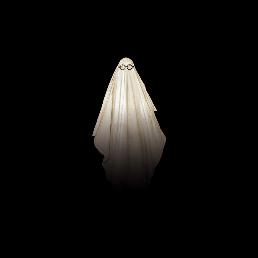 A white sheet wearing black circle glasses. It appears floating over a jet black background