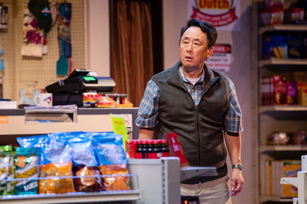 James Yi in a convenience store wearing a checked shirt