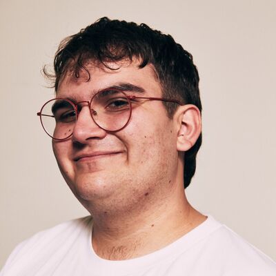 A white man with short dark hair and glasses