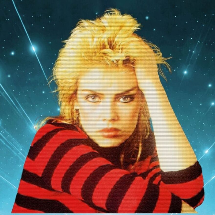 A young Kim Wilde looking into the camera wearing a black and red striped top with her hand on her head. There is a 1980s style TV filter over the image and shooting stars in the background