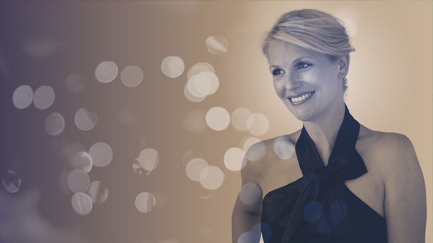 A white woman in a black halter neck dress