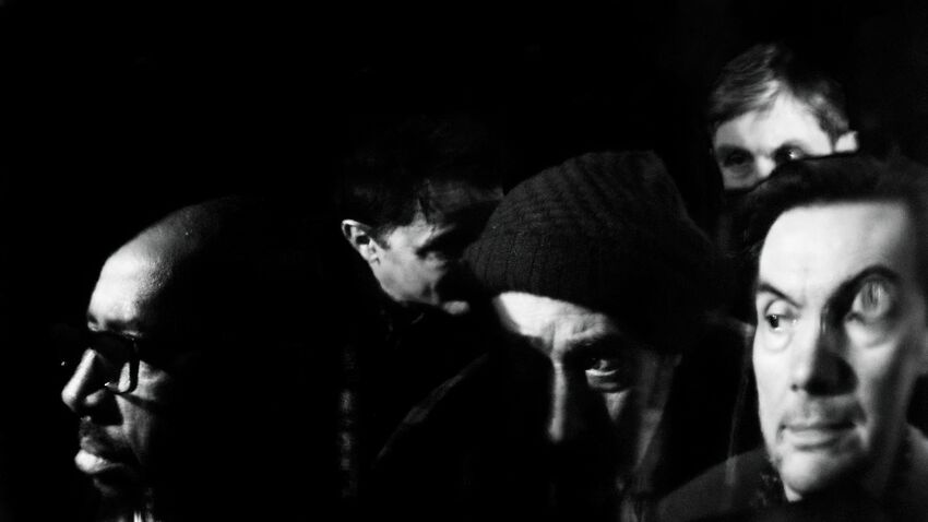 5 men's heads against a dark background