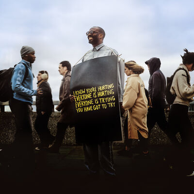 Joshua Idehen wearing a plaque with 