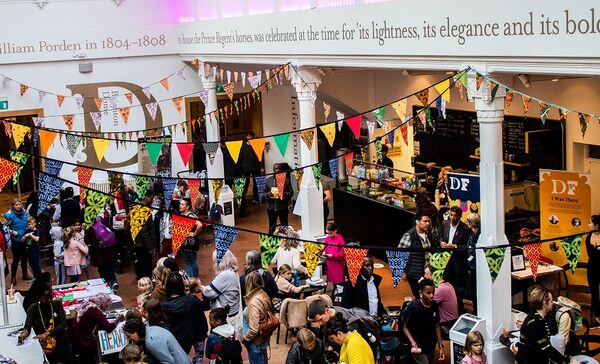 The Brighton Dome Foyer decorated with colourful bunting and filled with lots of people