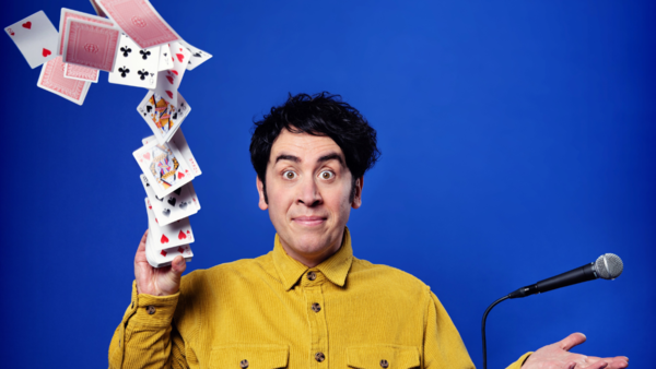 Pete Firman holding a microphone doing a card trick