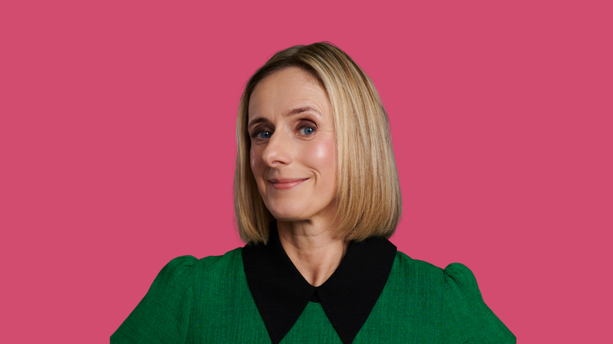 Marina Hyde wearing a green top with a black collar against a pink background