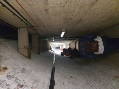 Image of people walking down a narrow brick tunnel