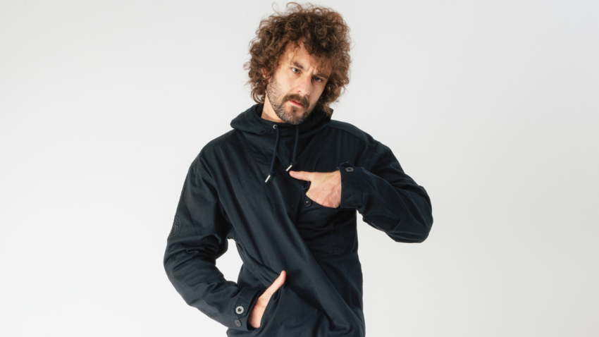 man in a black hoodie puts his hands in the pockets of the hoodie