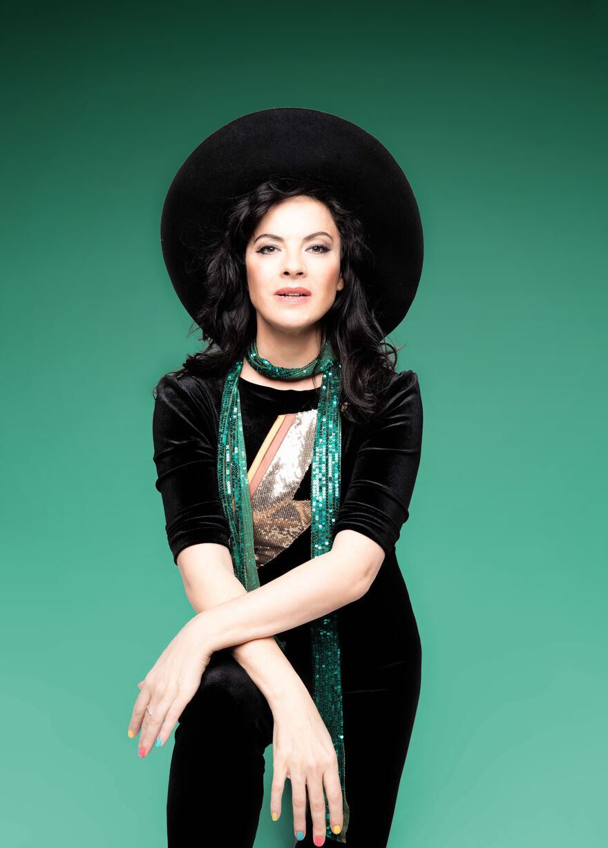 Camille O'Sullivan wearing a large black hat and glittery green scarf