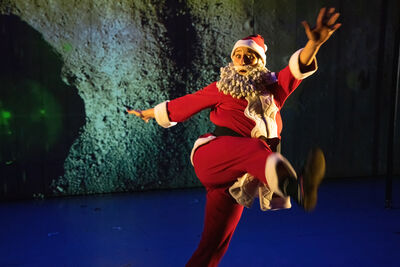 performers dressed as reindeers dance wsith santa 