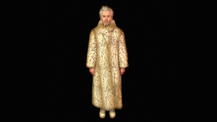 A man with white hair, dressed in a leopard-print floor-length fur coat. He is standing over a black background