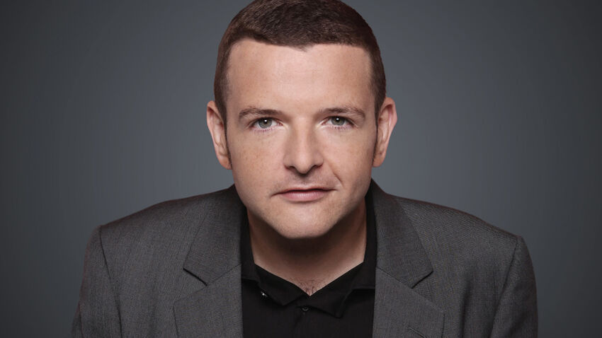 Kevin Bridges headshot with yellow background 