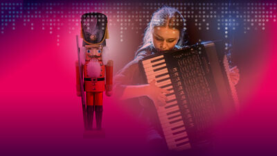 A nutcracker and a woman playing an accordian with a pink hue