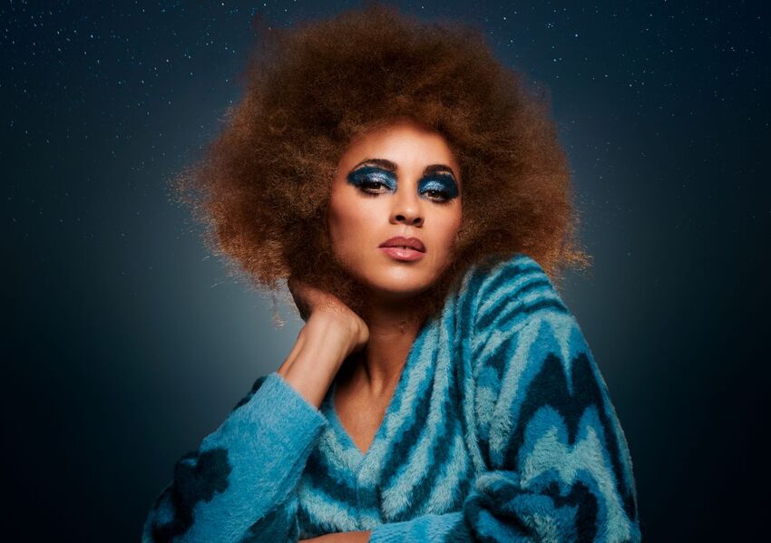 Michelle de Swarte with a blue swirly jumper and blue glittery eyeshadow