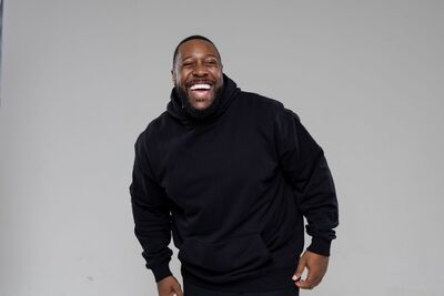 Aurie Styla wearing a black hoodie and laughing at the camera